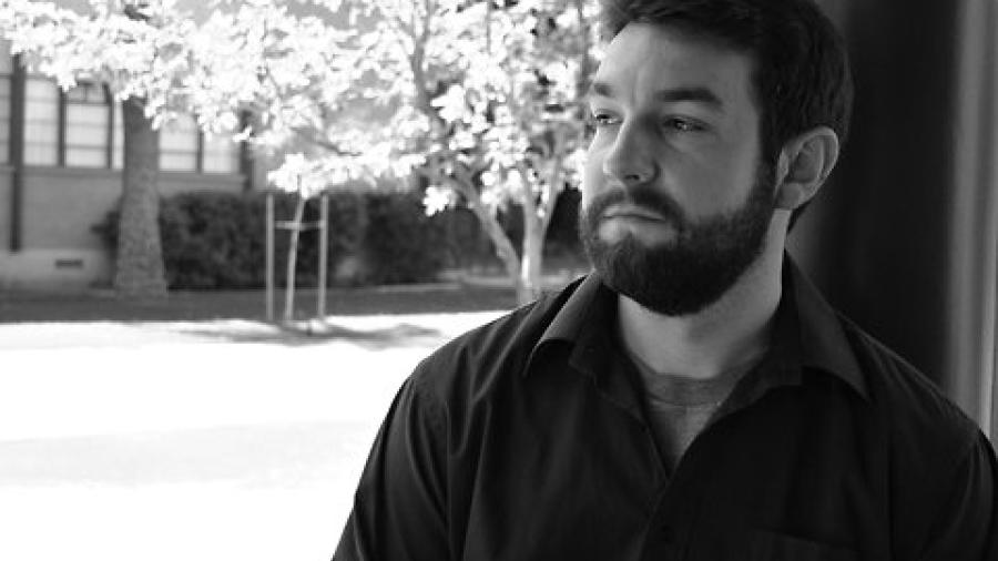 Black and white photo of pensive young man with beard