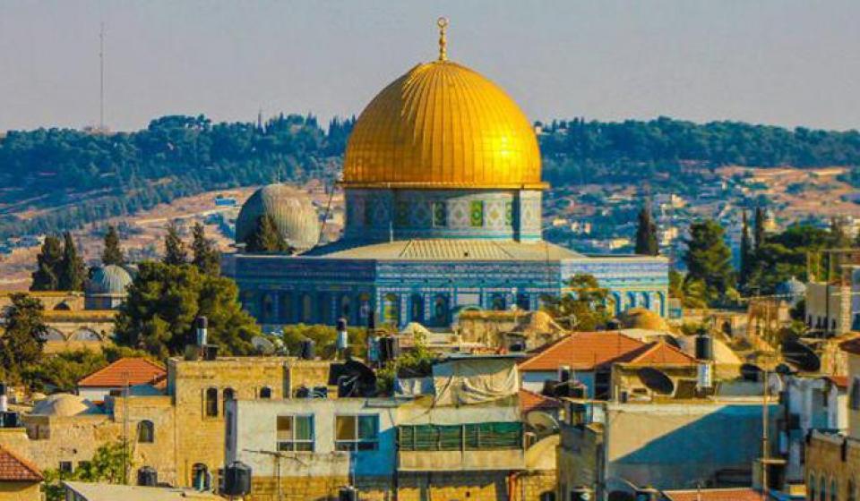 Dome of the Rock gold building in Jerusalem with hill in the background